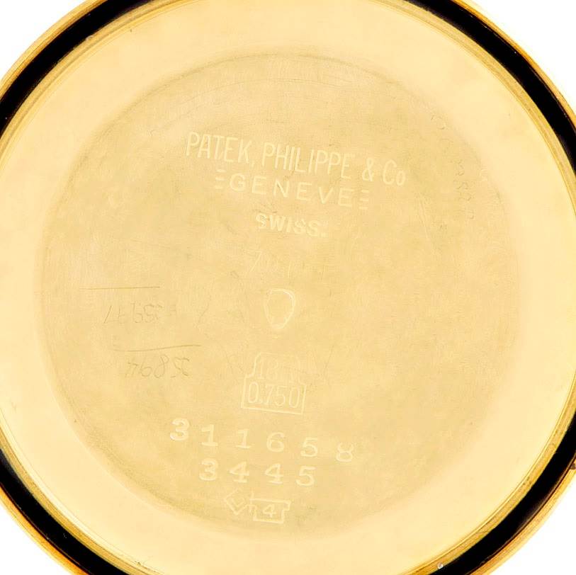 The image shows the inner case back of a vintage Patek Philippe watch with engraved markings.