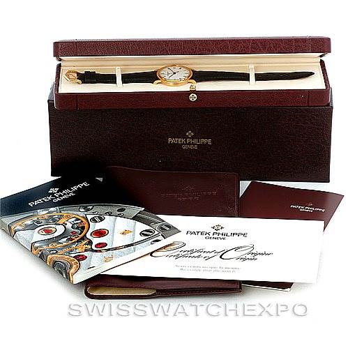 The image shows a Patek Philippe Calatrava 3802 Men's Yellow Gold White Dial 3802 Men's Yellow Gold White Dial watch in its box, with additional booklets and certificates displayed.