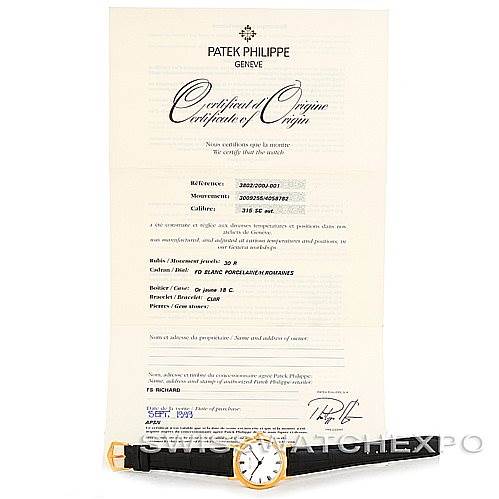 The image shows a Patek Philippe Calatrava 3802 Men's Yellow Gold White Dial 3802 Men's Yellow Gold White Dial watch laid flat with its certificate of origin displayed behind it.