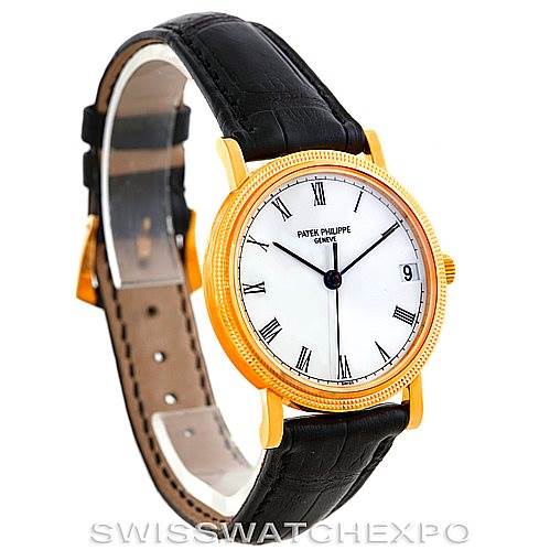 This Patek Philippe Calatrava 3802 Men's Yellow Gold White Dial 3802 Men's Yellow Gold White Dial watch is shown at an oblique angle, highlighting its gold case, white dial, black leather strap, and crown.