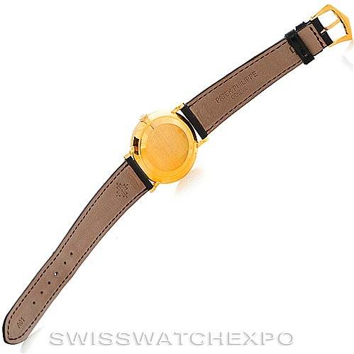 The image shows the backside of a Patek Philippe Calatrava 3919 Men's Yellow Gold White Dial 3919 Men's Yellow Gold White Dial watch, including the gold case and leather strap with the buckle.