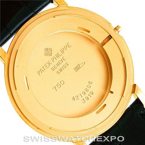 This image shows the case back of a Patek Philippe Calatrava 3919 Men's Yellow Gold White Dial 3919 Men's Yellow Gold White Dial watch in gold, including engravings and partial black leather straps.