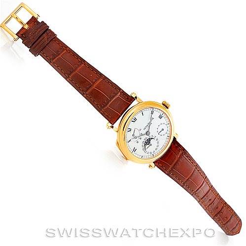 The image shows a top view of a Patek Philippe Complications 5054 Men's Yellow Gold White Dial 5054 Men's Yellow Gold White Dial watch with a brown leather strap and a gold case.
