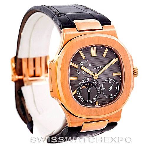 The image shows a Patek Philippe Nautilus 5712R Men's Rose Gold  5712R Men's Rose Gold  watch at an angled view, highlighting the face, bezel, crown, and part of the leather strap.