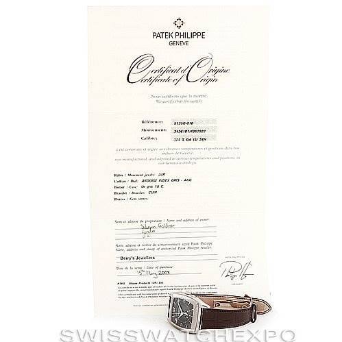 The image shows a Patek Philippe 5135G Men's White Gold Black Dial 5135G Men's White Gold Black Dial Complicated Annual Calendar Men's Watch 5135G on its side next to a certificate of origin.