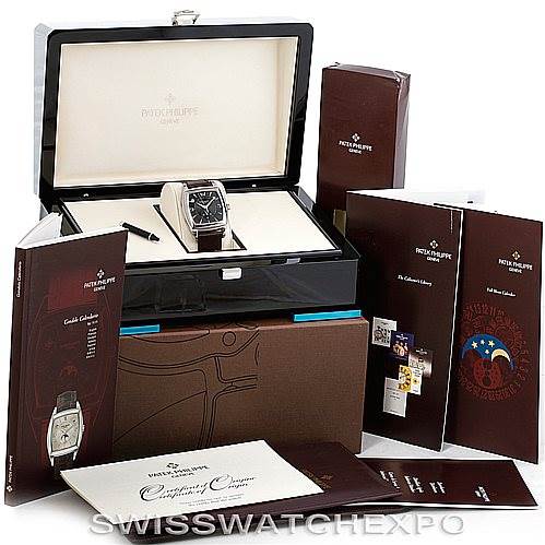 The image shows a Patek Philippe 5135G Men's White Gold Black Dial 5135G Men's White Gold Black Dial Complicated Annual Calendar 5135G watch in its box, surrounded by various manuals and accessories.