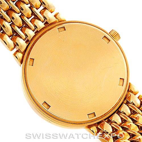 The image shows a top-down view of a Patek Philippe Calatrava 3998 Men's Yellow Gold Silver Dial 3998 Men's Yellow Gold Silver Dial watch, highlighting its round golden dial and linked bracelet.