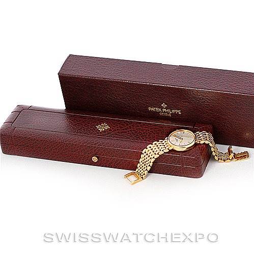 This image shows a Patek Philippe Calatrava 3998 Men's Yellow Gold Silver Dial 3998 Men's Yellow Gold Silver Dial watch with its bracelet draped over an open leather box, alongside its outer box.