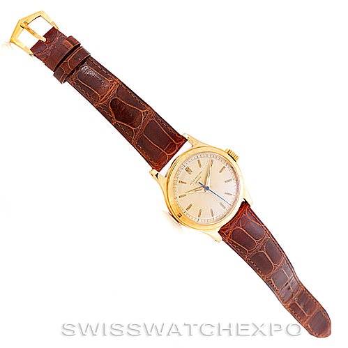 A Vintage Patek Philippe watch is shown from a top-down angle, displaying its face, leather strap, and buckle.