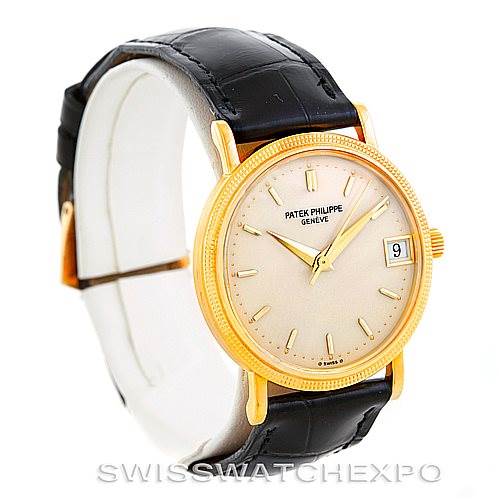 This image shows a side angle of a Vintage Patek Philippe watch, highlighting its gold case, dial, hands, markers, and black leather strap.