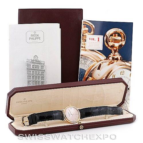 The image shows a Vintage Patek Philippe watch with a black leather strap and accessories, including booklets and a display box.