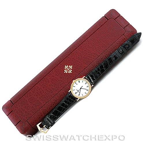 The image shows a Patek Philippe Calatrava 3944 Men's Yellow Gold White Dial 3944 Men's Yellow Gold White Dial watch with a black leather strap, placed on a maroon watch box.