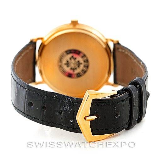 The image shows the back of a Patek Philippe Calatrava 3944 Men's Yellow Gold White Dial 3944 Men's Yellow Gold White Dial watch with a black leather strap and gold buckle.