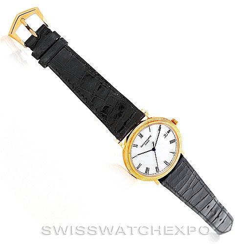 The image shows a Patek Philippe Calatrava 3944 Men's Yellow Gold White Dial 3944 Men's Yellow Gold White Dial watch at a top-down angle, highlighting its face, strap, and buckle.