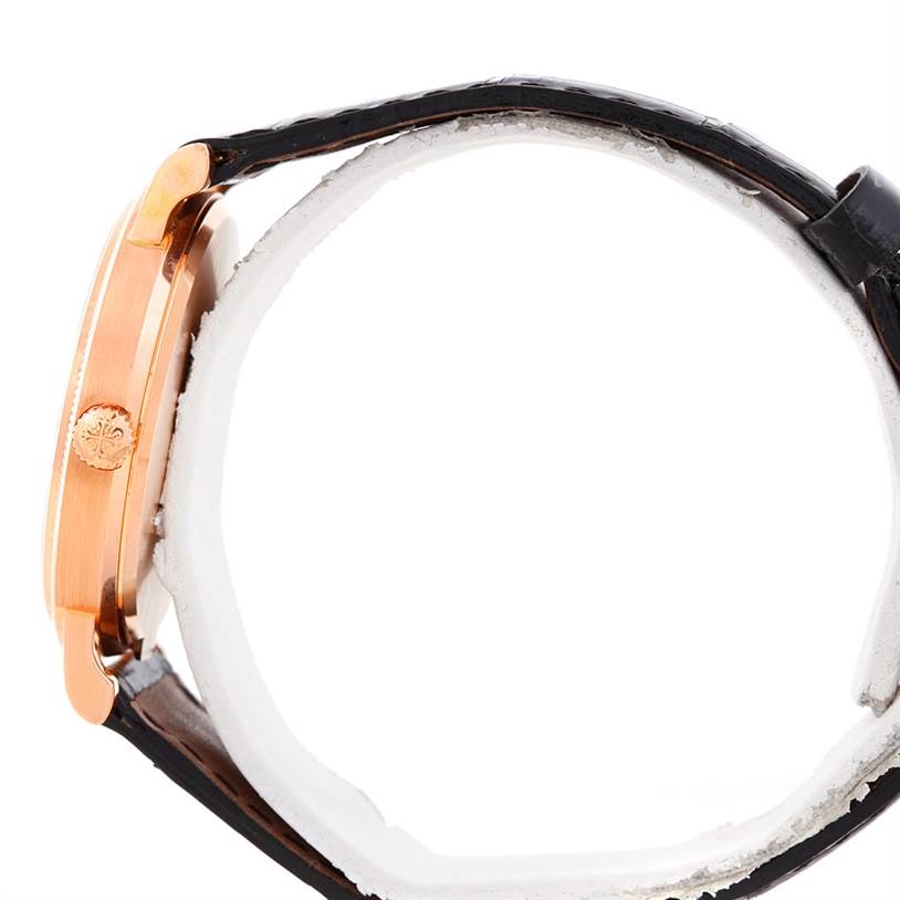 The image shows a side view of the Patek Philippe Calatrava 3802 Men's Rose Gold White Dial 3802 Men's Rose Gold White Dial watch, highlighting the crown and leather strap.