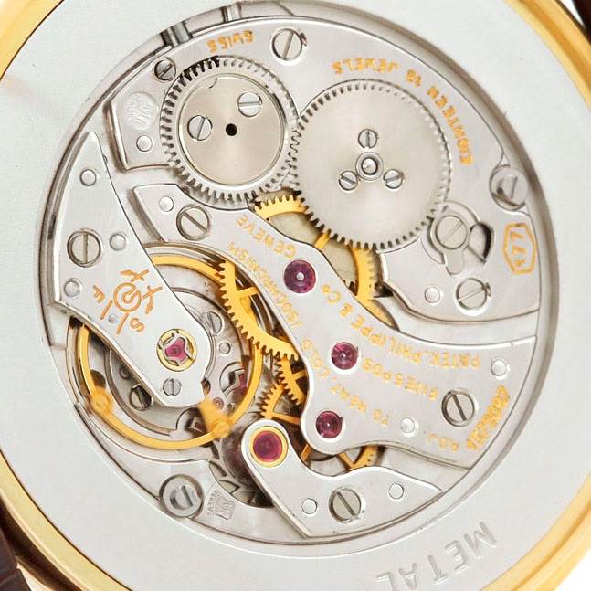 The image shows a close-up view of the movement mechanism inside a Vintage Patek Philippe watch.