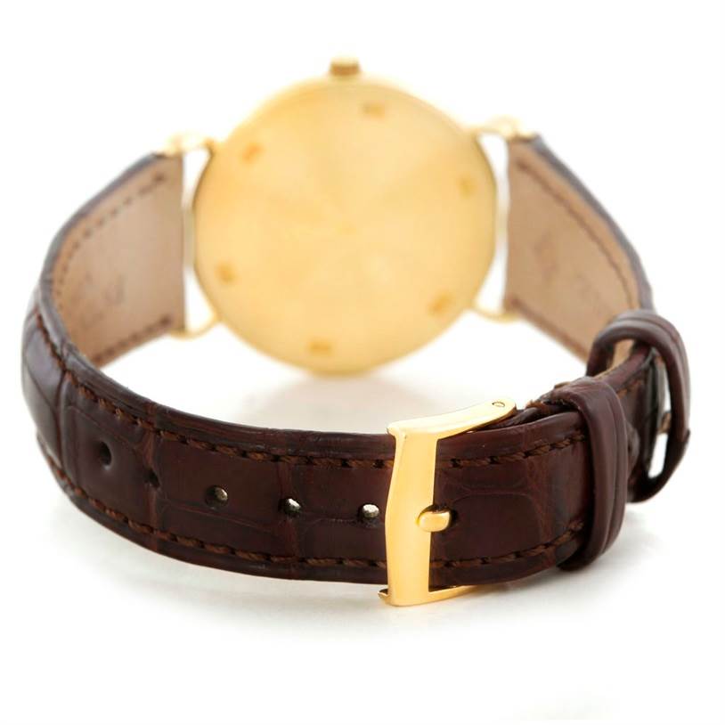 This image shows the back and strap of a Vintage Patek Philippe watch, highlighting its brown leather band and gold buckle.
