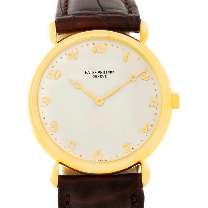 This image shows a front view of a Vintage Patek Philippe watch, highlighting its gold case, white dial, and brown leather strap.
