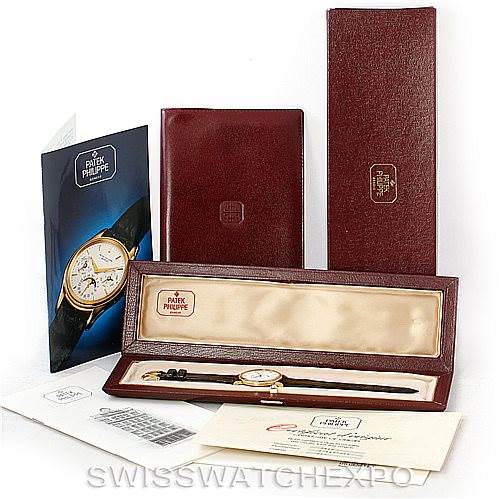 The image shows a Patek Philippe Calatrava 3919 Men's Yellow Gold White Dial 3919 Men's Yellow Gold White Dial watch, its case, manual, and associated accessories from an overhead angle.