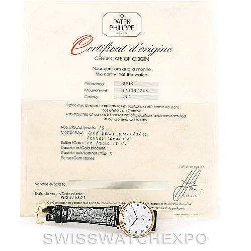The image shows a Patek Philippe Calatrava 3919 Men's Yellow Gold White Dial 3919 Men's Yellow Gold White Dial watch lying flat, along with its Certificate of Origin positioned directly behind the watch.
