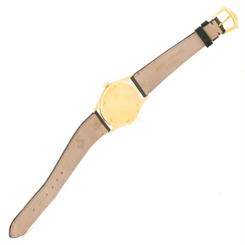 The image shows the back case and leather strap of a Patek Philippe Calatrava 5023 Men's Yellow Gold Silver Dial 5023 Men's Yellow Gold Silver Dial watch laid flat.