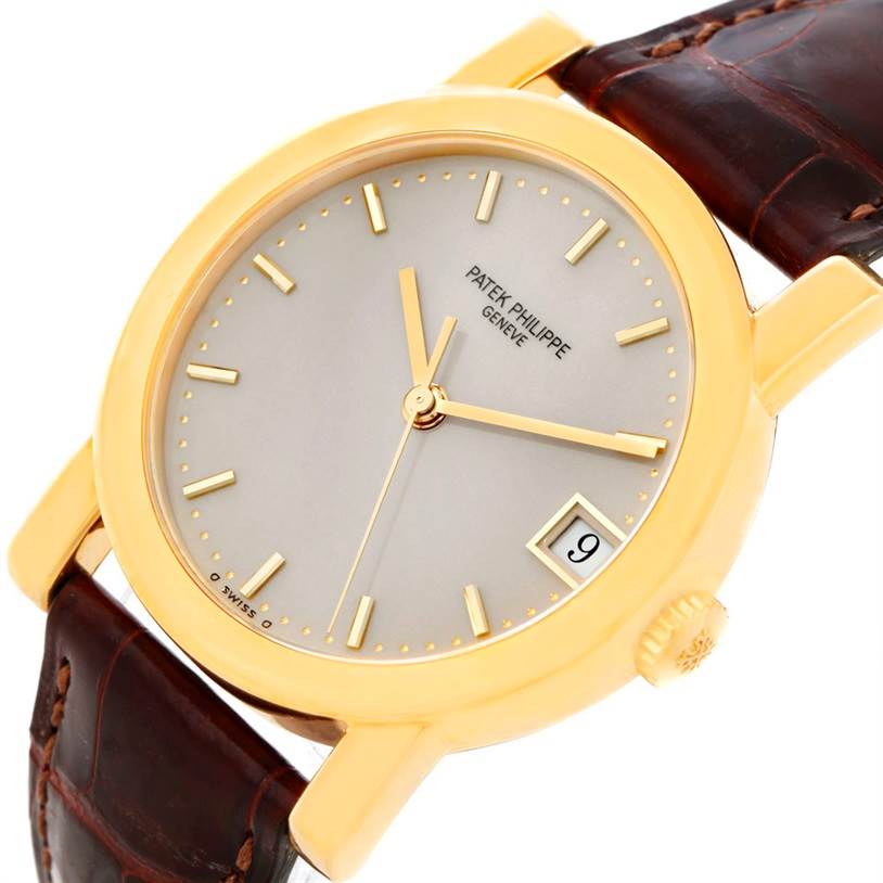 The Patek Philippe Calatrava 5012 Men
s Yellow Gold Beige Dial 5012 Men
s Yellow Gold Beige Dial watch is shown at an angled close-up, highlighting the face, crown, strap, and date window.