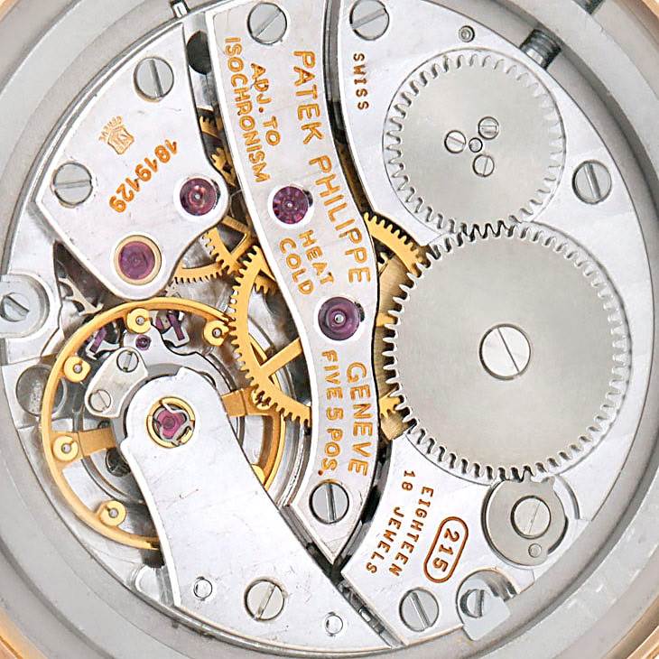 The image shows the movement and internal mechanics of a Patek Philippe Calatrava 3796R Men
s Rose Gold White Dial 3796R Men
s Rose Gold White Dial watch from a back view.