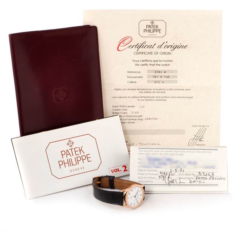 The image shows a Patek Philippe Calatrava 3796R Men
s Rose Gold White Dial 3796R Men
s Rose Gold White Dial watch along with its certificate of origin, warranty card, booklet, and a maroon document holder.