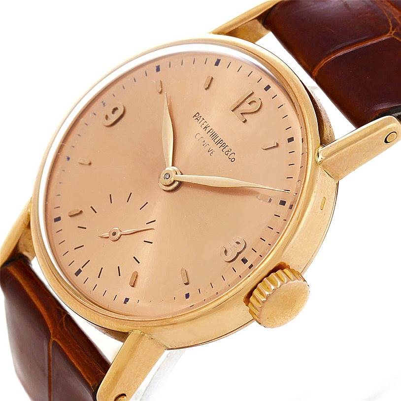 The image shows a close-up angled view of a Vintage Patek Philippe watch, highlighting the dial, crown, and leather strap.