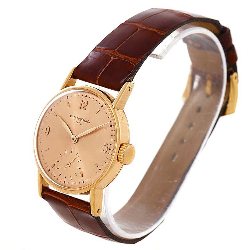 The image shows a Vintage Patek Philippe watch from a front diagonal angle, showcasing its gold case, dial, and leather strap.