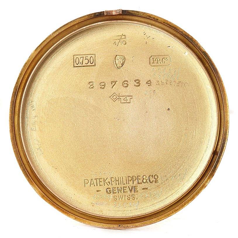 This image shows the inner case back of a vintage Patek Philippe watch, featuring various markings and inscriptions.