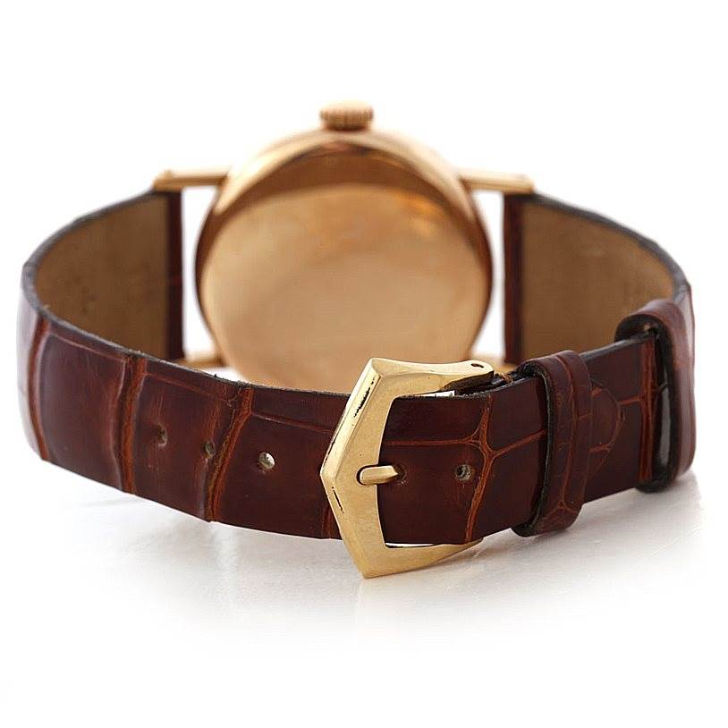This image shows the back of a Vintage Patek Philippe watch with a focus on its brown leather strap and gold buckle.