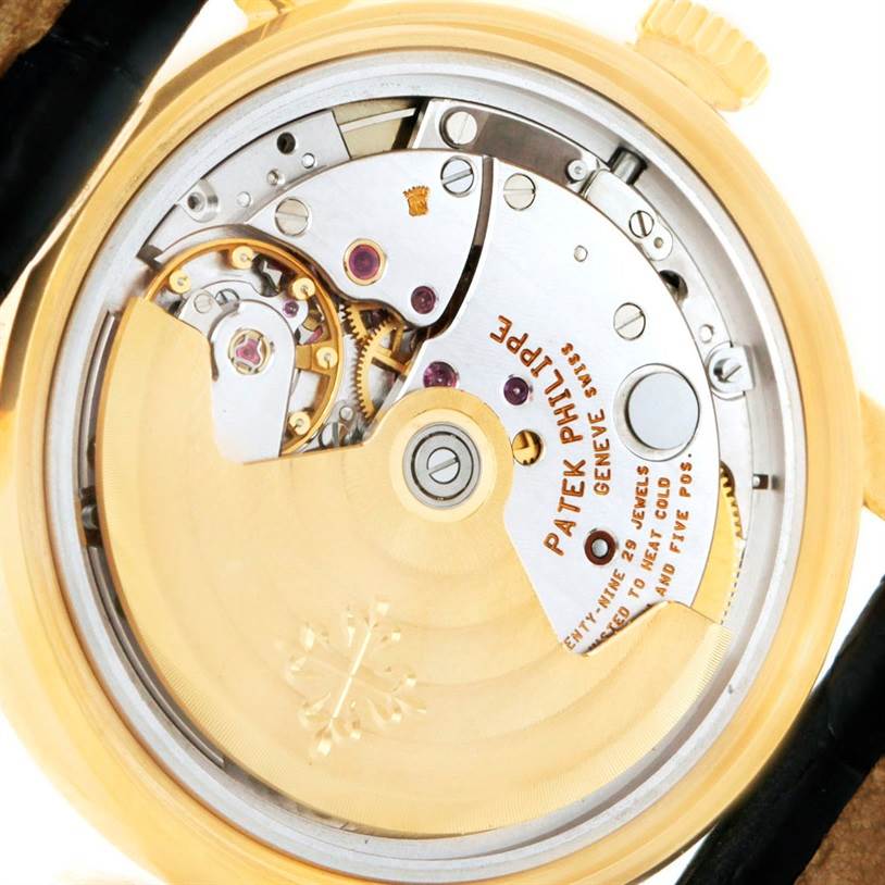 The image shows the back view of a Patek Philippe Calatrava 5012 Men
s Yellow Gold Beige Dial 5012 Men
s Yellow Gold Beige Dial watch, highlighting its intricate movement and mechanisms.