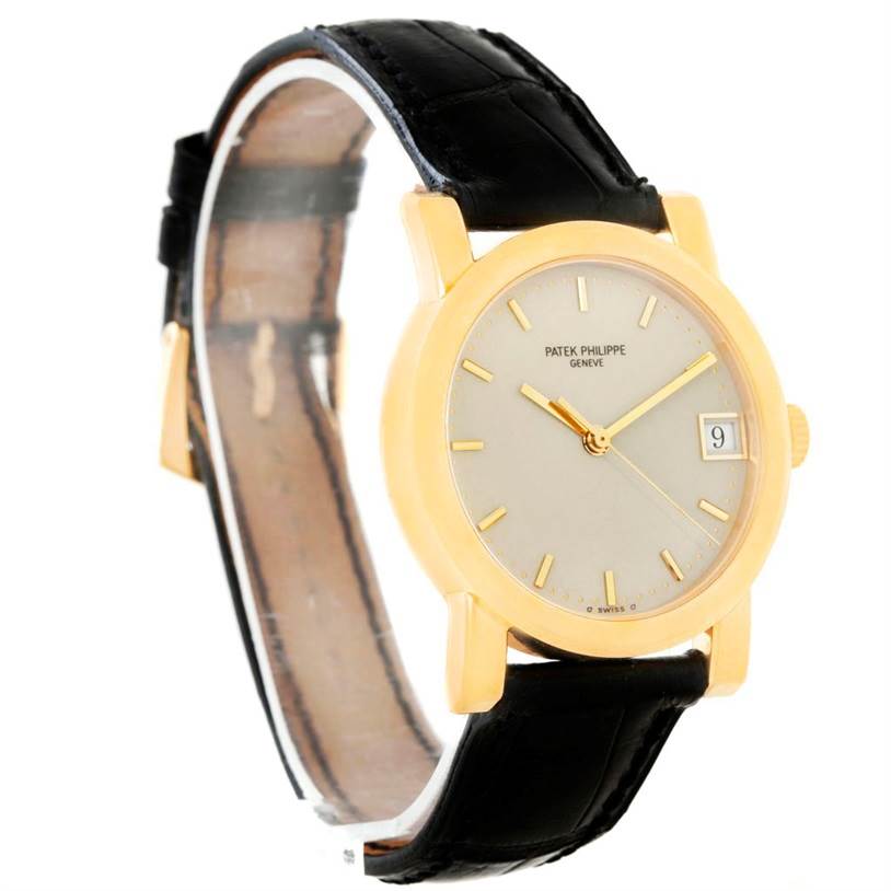 The Patek Philippe Calatrava 5012 Men
s Yellow Gold Beige Dial 5012 Men
s Yellow Gold Beige Dial watch is shown at a slight angle, displaying the face, date window, and black leather strap.