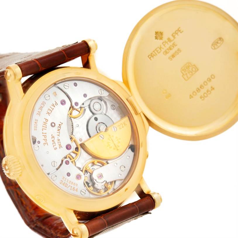 The image shows the open case back of the Patek Philippe 5054 Men's Yellow Gold White Dial 5054 Men's Yellow Gold White Dial Power Reserve Moonphase Yellow Gold Watch 5054, revealing the internal movement and engravings.