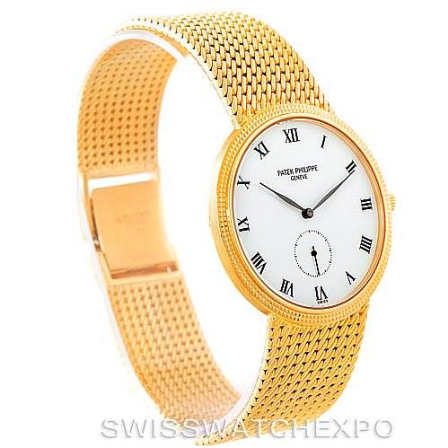 The image shows a Patek Philippe Calatrava 3919 Men's Yellow Gold White Dial 3919 Men's Yellow Gold White Dial watch from an angled side view, highlighting its gold mesh bracelet and white dial with Roman numerals.