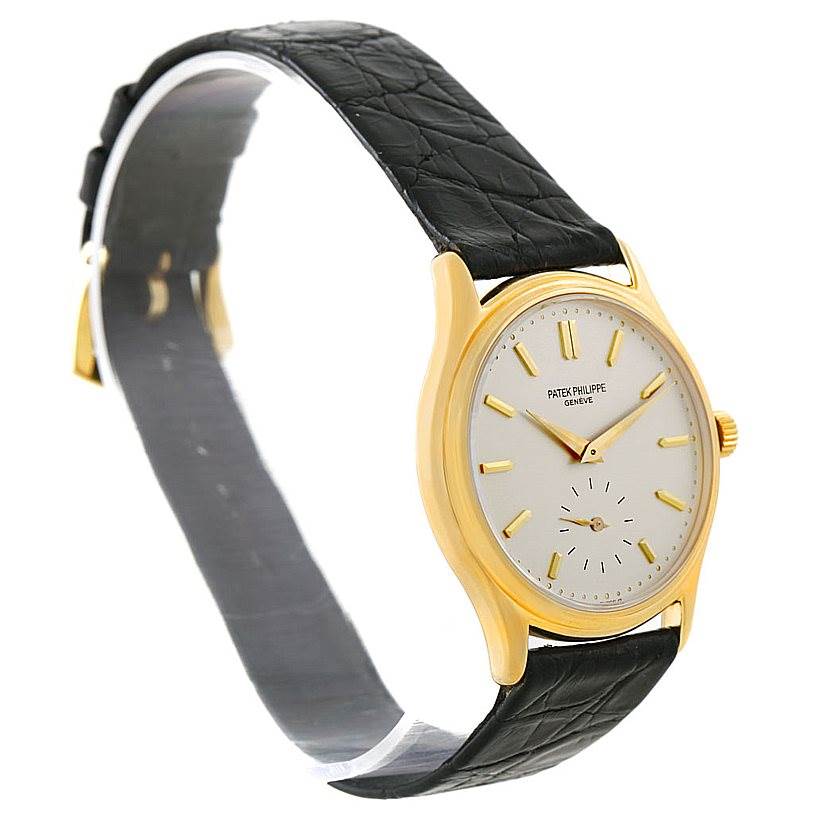 The Patek Philippe Calatrava 3923 Men's Yellow Gold Silver Dial 3923 Men's Yellow Gold Silver Dial watch is shown at a slight angle, displaying its face, gold casing, and black leather strap.