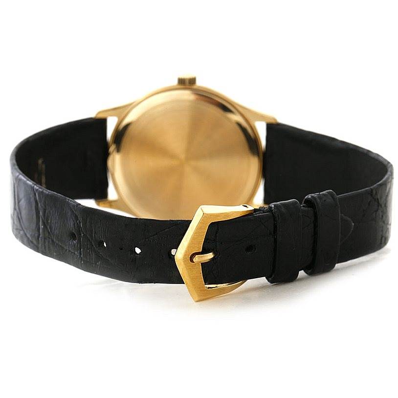 This image shows the back view of a Patek Philippe Calatrava 3923 Men's Yellow Gold Silver Dial 3923 Men's Yellow Gold Silver Dial watch highlighting its gold case and black leather strap with a gold buckle.