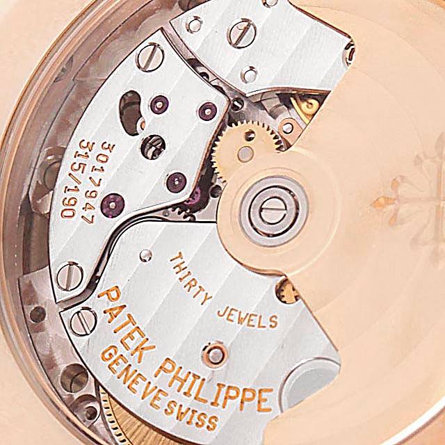 The image shows the detailed mechanical movement of a Patek Philippe Calatrava 5107R Men's Rose Gold Silver Dial 5107R Men's Rose Gold Silver Dial watch from a close-up, angled view.