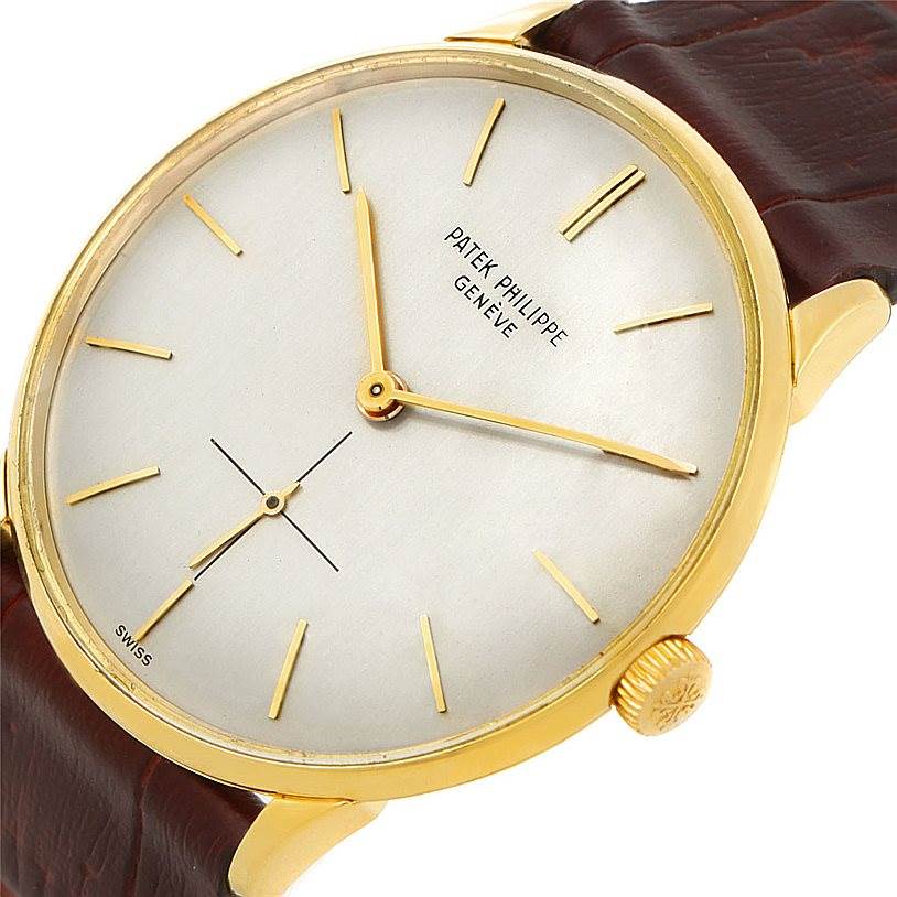 The Patek Philippe Vintage model watch is shown at a slight angle, displaying the face, hands, crown, and part of the strap.