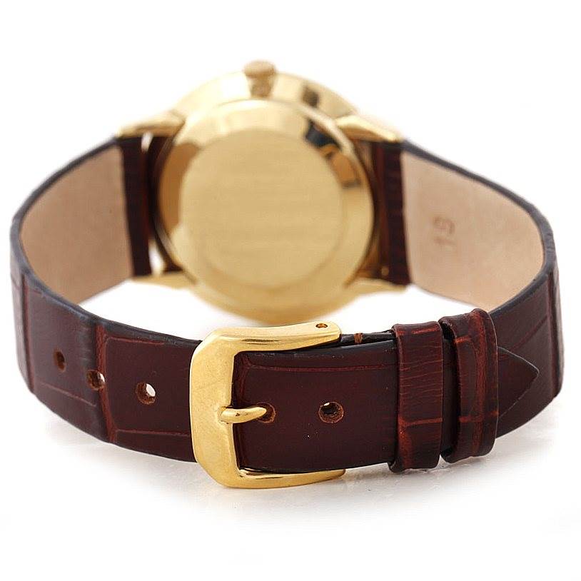 The image shows the back view of the Vintage Patek Philippe watch, highlighting the gold case and brown leather strap with a gold buckle.