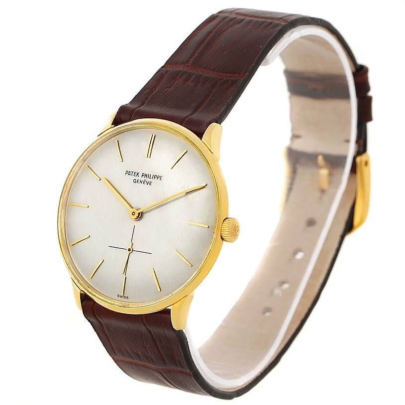 The image shows a side and slightly angled view of a Vintage Patek Philippe watch with a gold case and a brown leather strap.