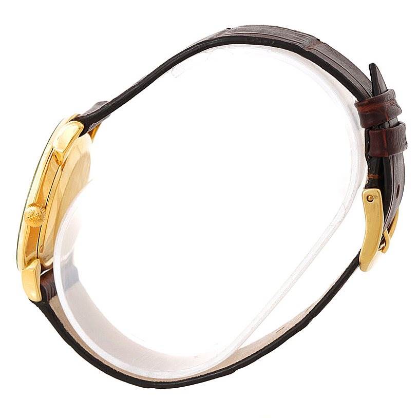 This Patek Philippe Vintage watch is shown from the side angle, highlighting its crown, case, and leather strap with buckle.