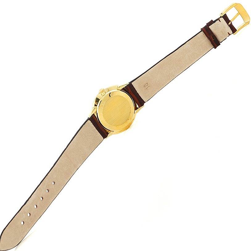 This image shows the backside of a vintage Patek Philippe watch, highlighting the gold case and straps.