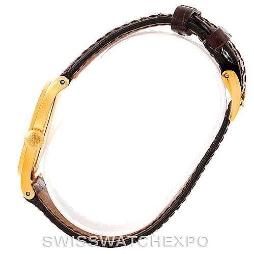 This image shows the side profile of a Vintage Patek Philippe watch, highlighting the gold case and brown leather strap.