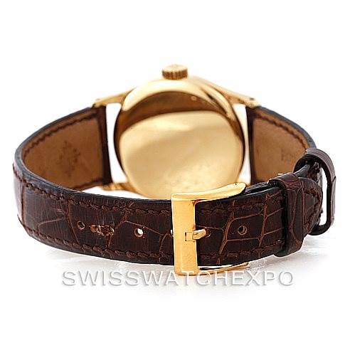 This image of the Patek Philippe Vintage watch shows its back case, crown, and brown leather strap with a gold buckle.