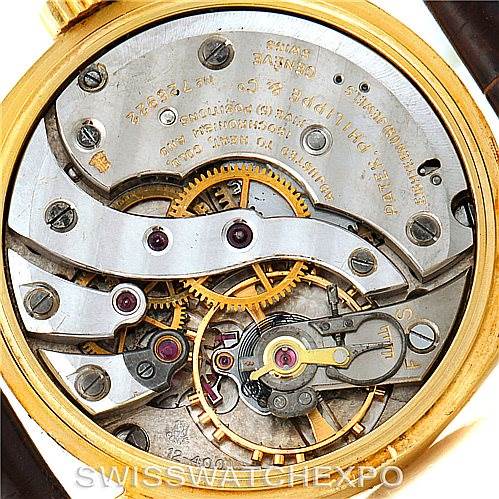 This is a close-up view of the movement mechanism of a Vintage Patek Philippe watch, showcasing gears, springs, and engravings.