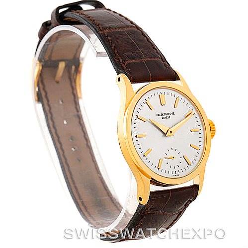 The image shows a side angle of the Patek Philippe Vintage watch, highlighting the gold case, white dial, leather strap, and crown.