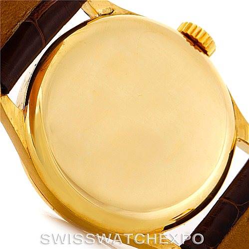 This image shows the back case and part of the leather strap of a Vintage Patek Philippe watch, focusing on the gold case and crown.