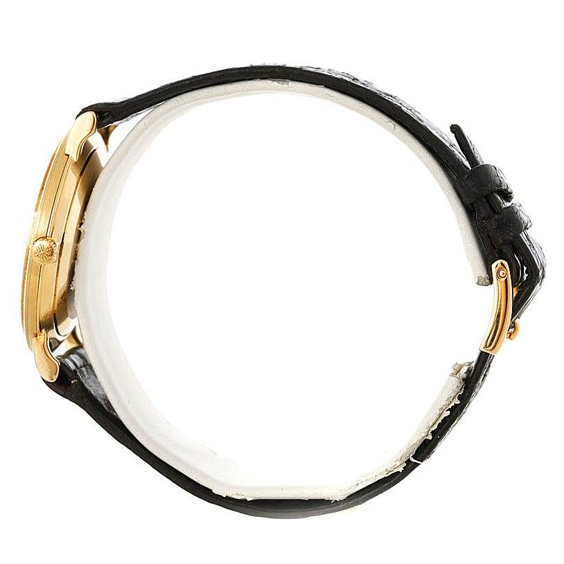 The image shows a side view of a Patek Philippe Calatrava 3919 Men's Yellow Gold White Dial 3919 Men's Yellow Gold White Dial watch, highlighting its gold case, black leather strap, and crown.